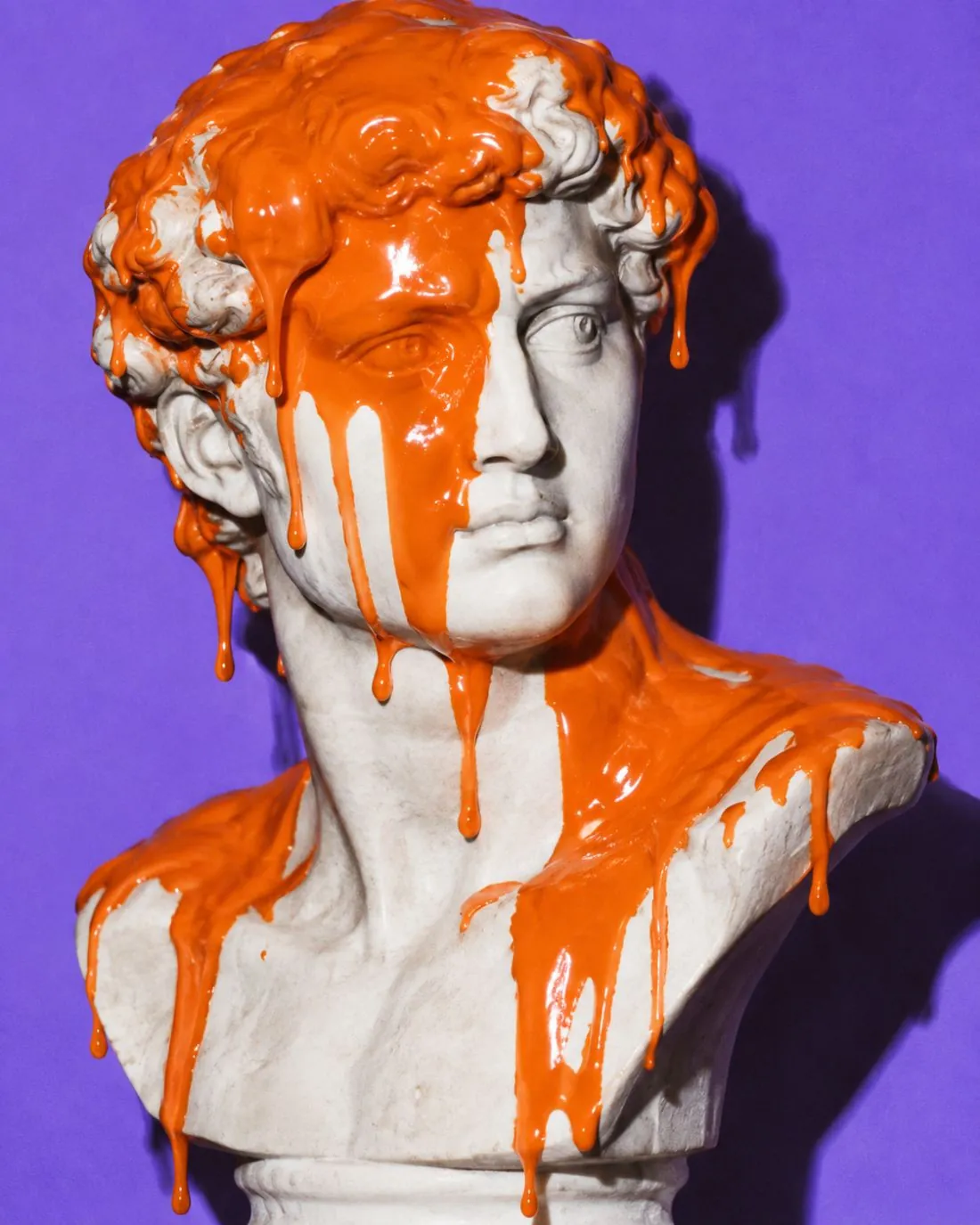 Marble bust with orange paint poured over its head
